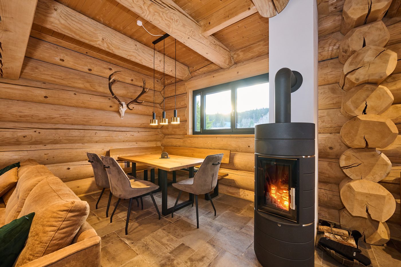 Essbereich mit Schwedenofen und Kaminfeuer im WoidSinn Chalet